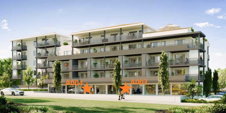 Immeuble moderne de plusieurs étages avec balcons et espaces verts devant.